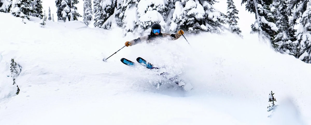 Freeride skier gliding through untouched powder in Revelstoke, British Columbia, showcasing epic snow conditions and mountain adventure